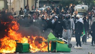 A student puts trashes into a fire as protesting students carry out blockading action near place de la Nation, in Paris, on October 2, 2026. Since late September, students have staged protests outside schools over grievances ranging from timetables, class sizes and a shortage of teachers to overheated classrooms during this year's heatwaves. The protests started in the Ile-de-France region around Paris but have now spread to other cities nationwide. 
Thomas SAMSON / AFP