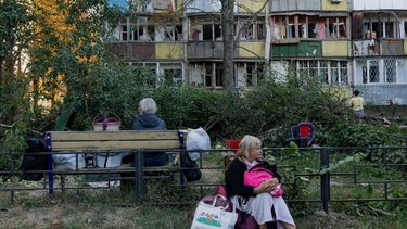 A woman sits near a damaged residential building following a Russian strike  in Kyiv on August 20, 2026, amid Russia’s invasion of Ukraine. Russian bombardment killed six people and wounded dozens in Ukraine's capital and its surrounding region overnight, authorities said on August 20.
Tetiana DZHAFAROVA / AFP