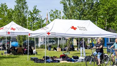 TER APEL - Asielzoekers bij het aanmeldcentrum, waar de opvanglocatie overvol is. De mensen zoeken de schaduw op in afwachting van het begin van hun aanmeldprocedure. MARCEL J. DE JONG / ANP