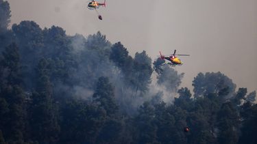 epa13093944 Two firefighting helicopters spread water over a forest fire in the town of Sentmenat, Barcelona, northeastern Spain, 07 July 2026. Some 77 Catalan firefighter squads are deployed in the area.  EPA/Quique Garcia