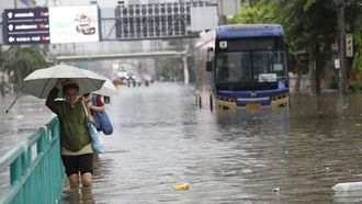 epa13264040 Residents wade through floodwater on a major street during a downpour in Bangkok, Thailand, 26 September 2026. All 50 districts in Bangkok have been declared flood disaster zones following persistent heavy rain caused by a strong low-pressure system combined with seasonal monsoon patterns.  EPA/RUNGROJ YONGRIT