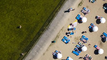 MUIDERBERG - Recreanten genieten van het lekkere weer op een strand in Muiderberg. Op tweede pinksterdag lopen de temperaturen op naar zomerse waarden. REMKO DE WAAL / ANP