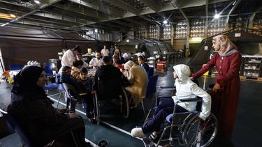 Military medical personnel and Palestinians, some on wheelchairs, are seated onboard the French LHD Dixmude military ship, which serves as a hospital to treat wounded Palestinians, as it docks at the Egyptian port of Al-Arish on January 21, 2024, amid ongoing battles between Israel and the Palestinian militant group Hamas in the Gaza Strip. 
Khaled DESOUKI / AFP