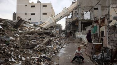 A Palestinian child rides a bicycle near a fallen minaret of a destroyed mosque during the Muslim holy fasting month of Ramadan, in the Nuseirat refugee camp in the central Gaza Strip on March 7, 2025.   
Eyad BABA / AFP