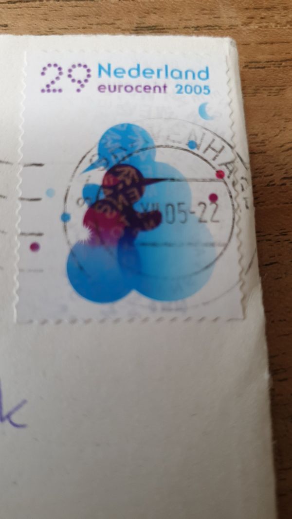 Een ingezoomde foto van een blauwe postzegel met het jaartal 2005 erop