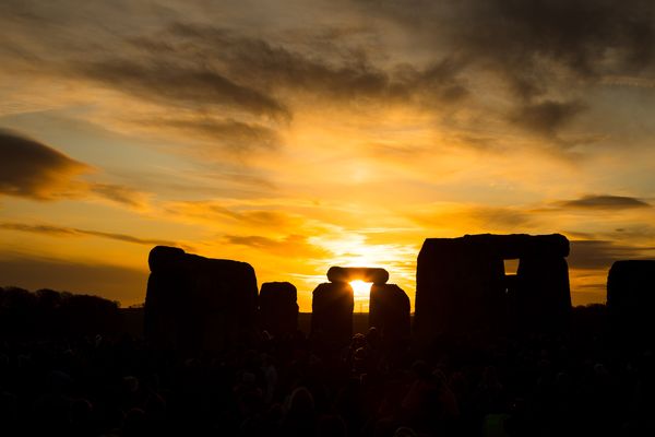 Een foto van Stonehenge als de zon achter de horizon verdwijnt.