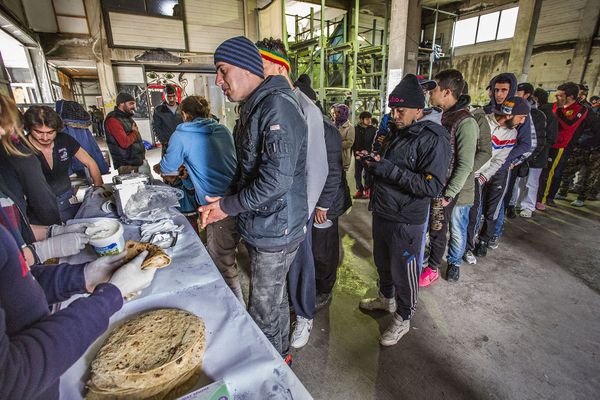 Op deze foto zie vluchtingen in de rij staan voor eten in een leegstaande cementfabriek op Lesbos.