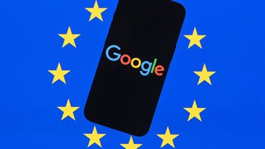 This illustration photograph shows the logo of Google displayed on a smartphone in front of an European Union flag in Brussels on September 29, 2025. 
Nicolas TUCAT / AFP
