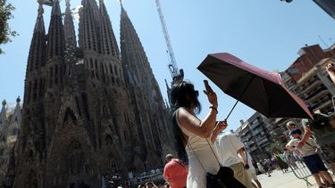 A woman uses an umbrella to protect from the sun during a heatwave while visiting La Sagrada Familia in Barcelona on July 7, 2026. Spain's AEMET weather agency on Tuesday declared a top level red heat alert in three eastern regions and predicted that temperatures would rise above 40C. The Aragon, Catalonia and Valencia regions are predicted to be among the worst hit in a new heatwave that is hitting southern Europe this week. Forecasters have said it will last until at least Thursday.

Lluis Gene / AFP