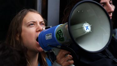 2023-10-19 10:26:51 epa10927096 Swedish climate activist Greta Thunberg shouts slogans through a megaphone as she takes part in a Fossil Free London protest outside JP Morgan and Barclays Headquarters at Canary Wharf in London, Britain, 19 October 2023. Climate activist Thunberg joined others during the climate change protest organized by the group Fossil Free London.  EPA/ANDY RAIN