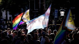 UTRECHT - Belangstellenden houden vlaggen omhoog tijdens een herdenking op het Domplein voor de slachtoffers van de aanslag in Berlijn, waar een man met een voertuig inreed op mensen bij de Pride. Er viel een dode en tientallen mensen raakten gewond. ROBIN VAN LONKHUIJSEN / ANP