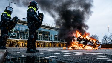 Een foto van de rellen in Eindhoven met een brandende auto
