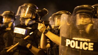 Op deze foto zie je politiemannen die vechten tegen betogers