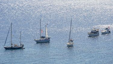 A group of ships of the Global Sumud Flotilla to Gaza are shown moored at the small island of Koufonisi, south of the island of Crete on September 26, 2025.  After a reported attack by drones early on September 25, 2025 morning, Athens has said it will guarantee safe sailing in its waters. The Global Sumud Flotilla, carrying activists including Swedish environmentalist Greta Thunberg, blamed Israel for more than a dozen explosions heard around its vessels off Greece late on September 24, 2025.
Eleftherios ELIS / AFP