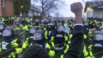 Zwarte man staat in Minneapolis voor politieleger en heft zijn vuist