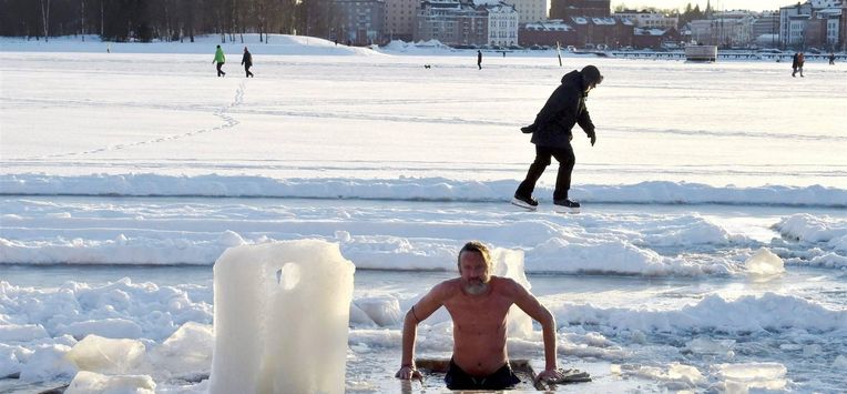 A winter swimmer takes a dip into water through sea ice in Helsinki, Finland on February 14, 2021. 
Jussi Nukari / Lehtikuva / AFP