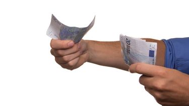 Een foto van mannenarmen met geldbiljetten in beide handen