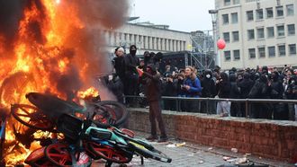 epa13291242 Protesters stand next to bicycles burning in a fire during a demonstration organized by national trade unions against the federal government's planned economic and wage reforms in Brussels, Belgium, 09 October 2026. Students have joined workers in the protest after a week of demonstrations against education reforms across Belgium, some of which have led to violent clashes with police.  EPA/OLIVIER HOSLET