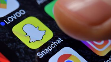 Een foto van de snapchat-app op een telefoon. Snapchat stopt promotie Trump