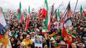 Participants hold up flags, among them the historic Iranian 