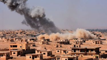 Rook stijgt uit boven gebouwen in de buurt van Bughayliyah, Syrië. Foto: AFP