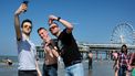 Een foto van jongens die op het strand van Scheveningen een selfie maken