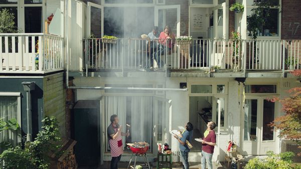 Een foto van film kijken op het balkon terwijl de buren barbecuen