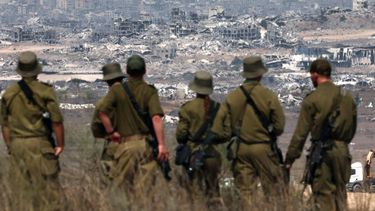 Israeli army soldiers look at destroyed buildings in the Gaza Strip as they stand on the border with the Palestinian territory, on August 13, 2025, while the war between Israel and the Palestinian Hamas militant group continues. 
Jack GUEZ / AFP