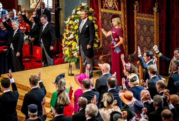 Op deze foto is een moment tijdens Prinsjesdag 2019 te zien, de koning en koningin staan, het is druk in de zaal.