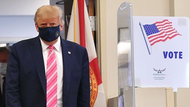 Op deze foto is president Donald Trump te zien, hij draagt een mondkapje.