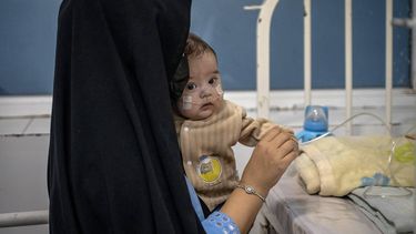 This photograph taken on January 8, 2026 shows an Afghan woman Najiba holding her child, Artiya, who is suffering from a congenital heart defect, inside the Medecins Sans Frontieres (MSF) therapeutic nutrition centre at a hospital in Herat. In the country of more than 40 million people, there are relatively few medical centres that can help treat malnutrition. Some families travel hundreds of kilometres (miles) to reach Herat hospital as they lack healthcare facilities in their home provinces.
Wakil KOHSAR / AFP