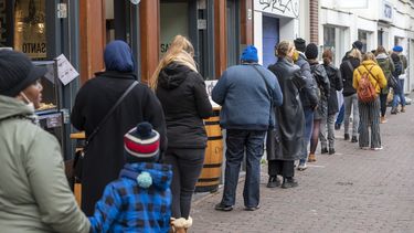 Een foto van een lange rij voor een winkel in Amsterdam, kort voor de lockdown