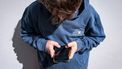 This photo taken on October 24, 2025 shows a 14-year-old boy posing at his home near Gosford as he looks at social media on his mobile phone.  Tech giants Meta and TikTok said on October 28 they will obey Australia's under-16 social media ban but warned the landmark laws could prove difficult to enforce. Australia will from December 10 force social media platforms such as Facebook, Instagram and TikTok to remove users under the age of 16. 
David GRAY / AFP