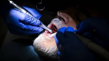 AMSTERDAM - Een persoon wordt behandeld in een mobiele tandartspraktijk. Vrijwillige mondzorgprofessionals bieden een gratis behandeling aan mensen voor wie een bezoek aan de tandarts normaal gesproken te duur is en vragen zo aandacht voor mondzorgarmoede. ANP RAMON VAN FLYMEN