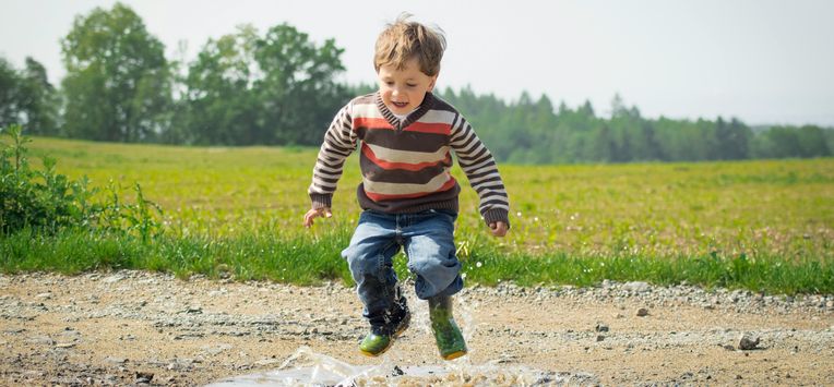 jongen springt in een plas water