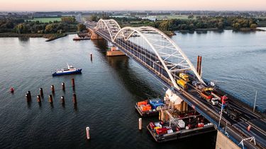 GORINCHEM - Een dronefoto van de werkzaamheden aan de Merwedebrug, welke in beide richtingen is afgesloten voor het verkeer. De huidige asfaltlaag wordt verwijderd waarna er een lichtere en dunnere asfaltlaag wordt aangebracht. Daarmee wordt het gewicht van de brug verminderd, wat nodig is om de brug veilig te kunnen gebruiken tijdens de bouw van de nieuwe Merwedebrug. JEFFREY GROENEWEG / ANP