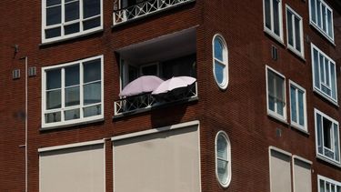 AMSTERDAM - Twee parasols op een balkon in Amsterdam. In het hele land geldt de waarschuwing code rood vanwege extreme hitte. JORIS VAN GENNIP / ANP