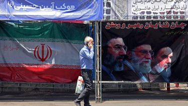 A man walks past Iran's national flag and a banner bearing the images of the late founder of the Islamic Revolution supreme leader Ayatollah Ruhollah Khomeini (R), the late Iranian supreme leader Ali Khamenei and his son, the current supreme leader Mojtaba Khamenei (L), erected along a street at the Vanak Square in Tehran on June 10, 2026. Iran's foreign ministry said on June 10 that the United States had damaged the ongoing international diplomatic effort to end the war, after more US strikes on targets in southern Iran.
ATTA KENARE / AFP