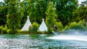 Foto van twee tipi-tenten en een watersporter
