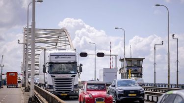 GORINCHEM - Vrachtwagens rijden over de Merwedebrug, waar een verbod voor vrachtverkeer geldt nadat een controle had uitgewezen dat de stalen boogconstructie verzwakt is. Om het verbod te kunnen handhaven, zijn er camera's opgehangen. ROBIN VAN LONKHUIJSEN / ANP