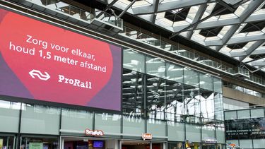 Een foto van een bord met de 1,5 meter-waarschuwing op station Den Haag Centraal