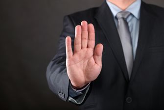 Een foto van een hand met het gebaar 'nee, stop'