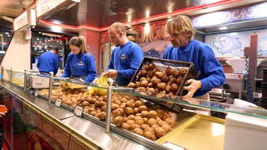 DEN HAAG - Klanten in de rij bij Vermolens oliebollenkraam in Den Haag op oudjaarsdag. Hoewel bijna alles duurder is geworden, kopen Nederlanders dit jaar net zoveel oliebollen als vorig jaar. ANP PHIL NIJHUIS