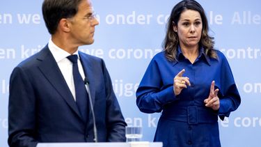 Een foto van premier Rutte en Irma Sluis tijdens een persconferentie over de coronamaatregelen