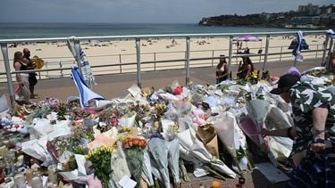 epa12606406 People continue to bring flowers to the Bondi Beach promenade as crowds return to Bondi Beach on the a day of National Reflection one week on from the Bondi Massacre  in Sydney, Australia, 21 December 2025.  EPA/DEAN LEWINS AUSTRALIA AND NEW ZEALAND OUT