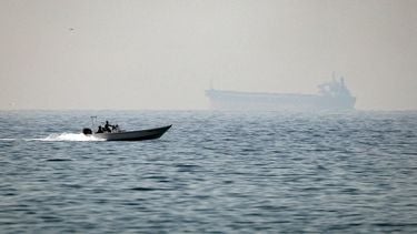 (FILES) A motorboat cruises along the shore off the town of Al Jeer on the Strait of Hormuz in the northern emirate of Ras Al Khaimah, with a tanker seen in the background, on February 25, 2026.
 The US president sent a peace plan to Iran as he voiced optimism on March 25, 2026 at ending nearly a month of warfare, with Tehran announcing that it will let 