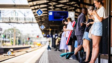 DORDRECHT - Mensen wachten in de hitte op de trein op een NS station. In het hele land geldt de waarschuwing code rood vanwege extreme hitte. JEFFREY GROENEWEG / ANP