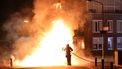 Een lid van de brandweer blust een brand.