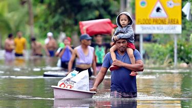 Residents evacuate from their flooded homes due to heavy rain brought by Typhoon Fung-wong in Remedios T. Romualdez, on the southern island of Mindanao on November 8, 2025.
 Rescue work was suspended and preemptive evacuations began on November 8 as Typhoon Fung-wong bore down on the Philippines, days after another storm killed at least 204 people.
Erwin MASCARINAS / AFP