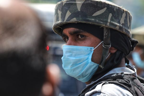 Een foto van een beveiliger met mondkapje in India